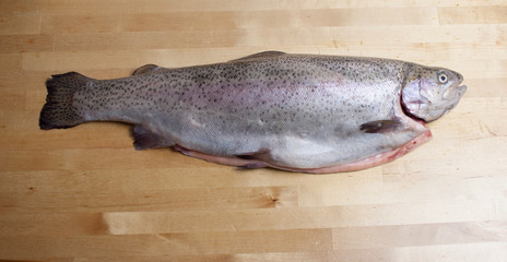 Cutting gutted red fish trout sweetfish on wood background