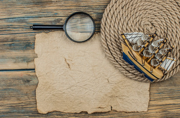 old paper and model classic boat on wood background