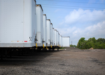 Long row of empty trailers on a summer day in Texas waiting for work