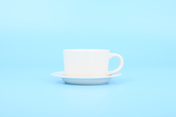 White coffee cup with saucer isolated on blue pastel background
