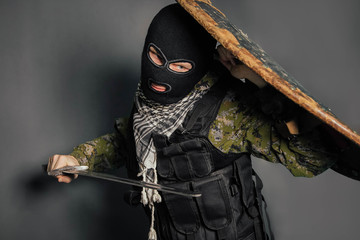 Modern warrior with medieval weapons in his hands. A soldier defends himself with a shield and...