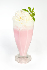 Milk cocktail with strawberries with whipped cream and a froth in a glass on a white background