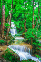 The beautiful Erawan cascade waterfall with turquoise water like heaven and sunlight at the...