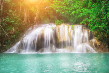Fototapeta na wymiar The beautiful Erawan cascade waterfall with turquoise water like heaven and sunlight at the tropical forest ,Kanchanaburi National Park, Thailand