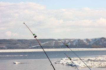 fishing gear on a blurred background of a spring river with floating ice floes