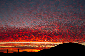 Scenic violet sunset sky with orange and yellow colored clouds