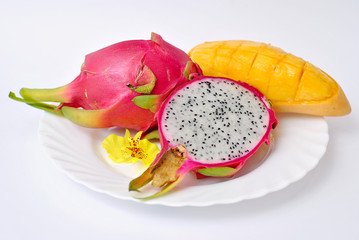 Fototapeta na wymiar Close up view of exotic dragon fruit with mango cut and whole sliced isolated on white background with petals.