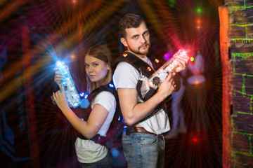 Couple standing back to back in laser beams