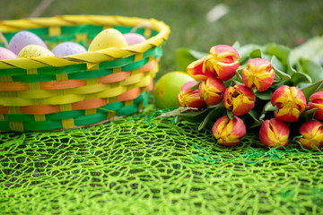 Fototapeta na wymiar Different color Easter egg on a grass with flowers