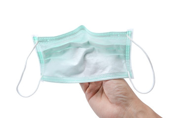 Hand holding medical mask or surgical earloop face mask isolated on white background with clipping path. anti virus and bacteria protective face air pollution, environmental and protection concept.