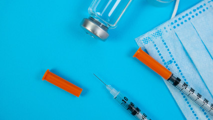 Syringe for Insection, Yellow tablets and Stethoscope As Background. Vaccine and paper notebook. Concept of clinic or hospital, health care or doctor. Medical Equipment on blue surface