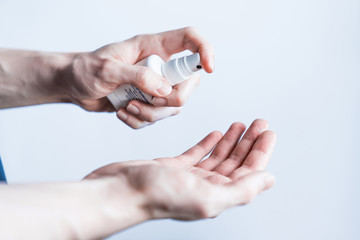 Close up of hands using hand sanitizer against virus or 2019-nCoV over white background. Hygiene and Healthcare concept