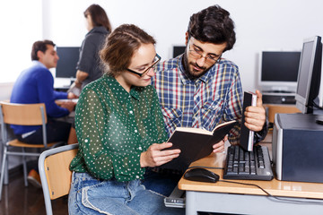 Fototapeta premium students reading textbook together while studying