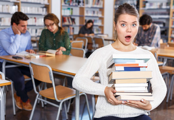 Surprised girl sitting in library