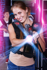 girl with laser pistol in her hands playing laser tag game