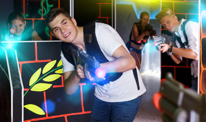 Positive guy with  laser pistol during playing lasertag with his