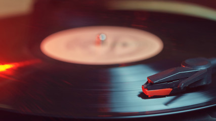 Retro record player with a spinning black vinyl record © Luka