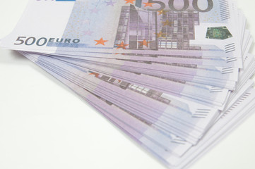 a stack of five hundred Euro notes on a white background is spread out like a fan top side view close up