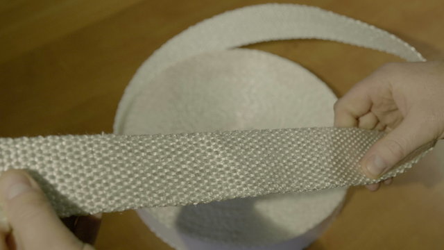 Men's hands hold a skewed non-flammable fabric