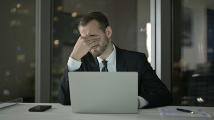 The Sleepy Businessman keep working on Laptop at Night