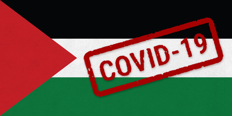 Flag of Palestine on paper texture with stamp, banner of Coronavirus name on it. 2019 - 2020 Novel Coronavirus (2019-nCoV) concept, for an outbreak occurs in the Palestine.
