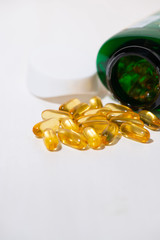 dietary supplement - fish oil capsules on white background, vertical
