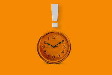 Shot of yellow wall clock isolated on a yellow colored background with an exclamation mark on above...