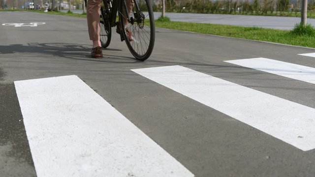 Bike stops before pedestrian crossing lines on bike lane ath the city park.