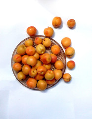 Bright orange apricots on a glass plate. Fruits on white background