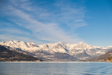 Snowy peaks of Alps mountains on a clear sunny day, panorama of Lago di Como