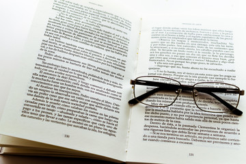 occhiali appoggiati sul libro aperto