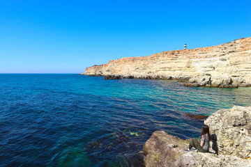 Fototapeta na wymiar Beautiful blue bay, waves, lighthouse, girl,coastline