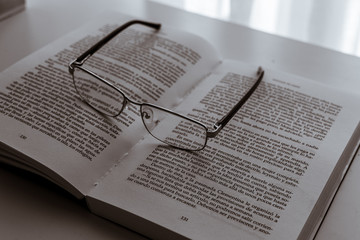 occhiali appoggiati sul libro aperto