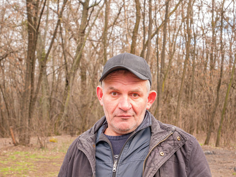 Facial expression of a mature man in a baseball cap with gray hair. People. Place for text. Background image.