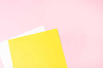 White and yellow blank paper on pink background. Empty free space. background. 