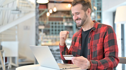 Fototapeta premium Successful Online Payment on Laptop by Beard Young Man