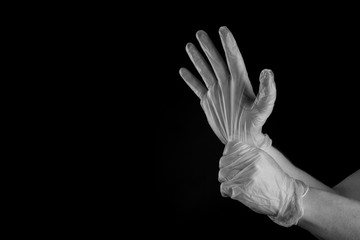 Man putting medical rubber gloves on , isolated on black background copy space