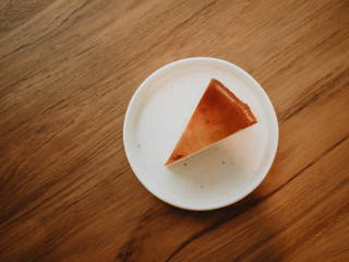 Basque Burnt Cheesecake on plate with piece of cake on wooden table