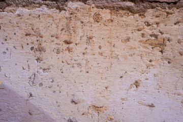 Weathered white wall with stains of paint, dust and cement.