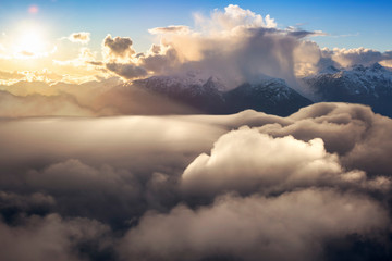 Cloudscape and Mountains Background. Beautiful and striking aerial view of the puffy clouds during a colorful and vibrant sunset or sunrise. Landscape taken in British Columbia, Canada. composite