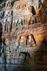 Painted walls with buddha and monk statues in niches. World cultural heritage site and Buddhist Caves Art Treasure Houses in Yungang Grottoes near Datong, Shanxi Province, China 