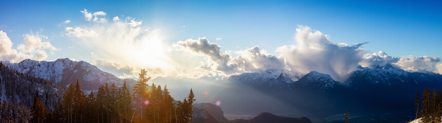 Beautiful Dramatic Canadian Mountain Landscape View during a sunny and cloudy winter sunset. Taken in Squamish, British Columbia, Canada. Nature Background Panorama