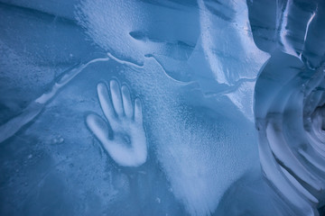 Human Hand Imprint on the Ice Wall in the Natural Cave during winter. Taken in Blackcomb Mountain, Whistler, British Columbia, Canada. Concept: Peace, Humanity, Unity