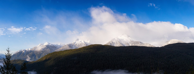 Panoramic Canadian Landscape View of the Rocky Mountain Peaks during a cloudy morning. Taken in Tantalus Lookout near Squamish and Whistler, North of Vancouver, BC, Canada. Background Panorama
