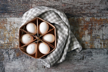 Fresh homemade eggs in a wooden tray. White eggs. Eco products.