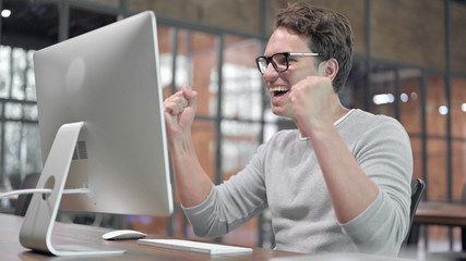 Success Guy Celebrating while Working on Computer