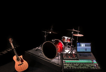 Digital mixer in a recording Studio , with a computer for recording music. On the background of a drum set and musical instruments.