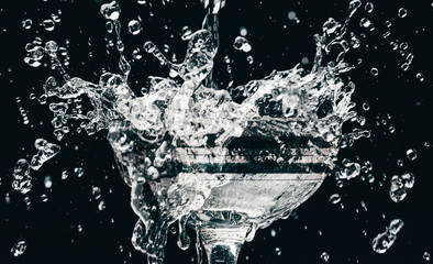 Ice cubes splashing into glass of water, isolated on white