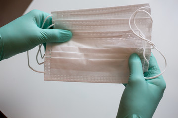 Hands in medical gloves puts on a mask. Coronavirus. Covid 2019.