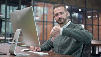 Smart Man Working on Computer and Showing Thumbs Down